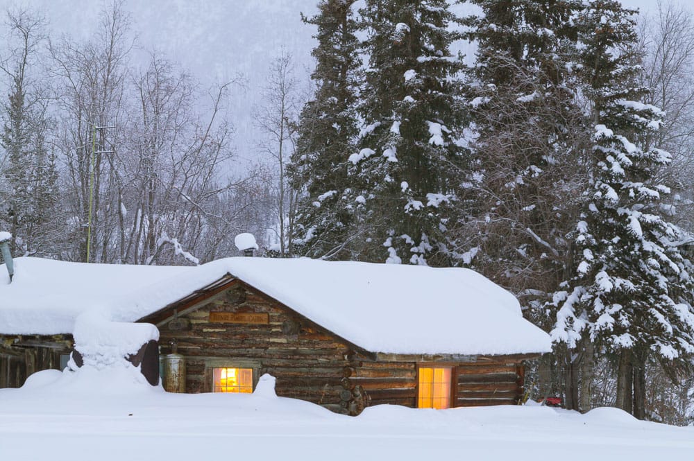 Historic log cabin laden with fresh snow